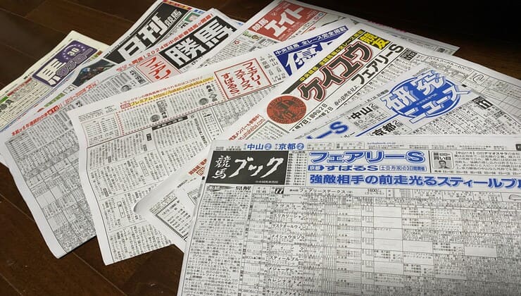 競馬新聞がたくさん並んでいる画像